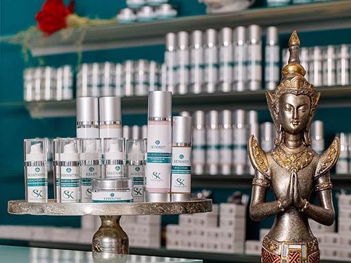 Hautpflegeprodukte und eine Buddha-Statue in einem Naturkosmetikgeschäft, entspannte Atmosphäre.